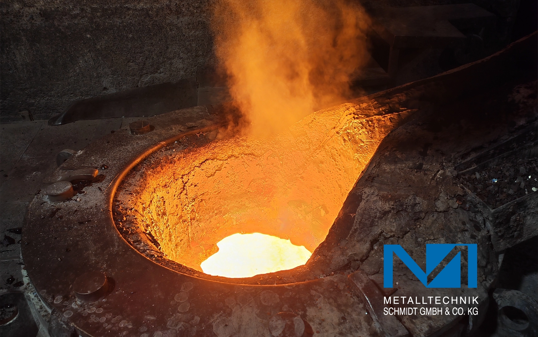 Schmelzofen mit flüssigem Metall im Inneren, orange beleuchtet, zieht sich Dampf hoch. Umgebung rau und industriell.