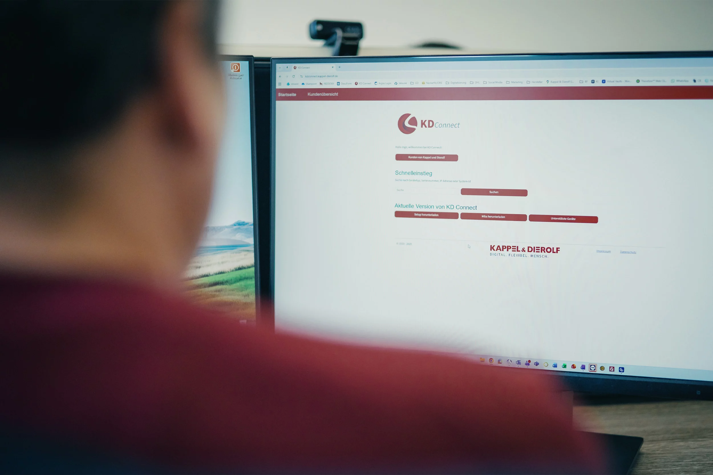 Eine Person vor einem Bildschirm mit geöffneter Website KDConnect von Kappel & Dierolf in einem Büro.