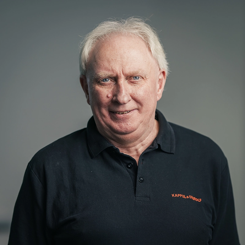 Es tut mir leid, ich weiß nicht, wer diese Person ist.ALT-Text: Älterer Mann mit grauen Haaren, dunklem Shirt vor neutralem Hintergrund.