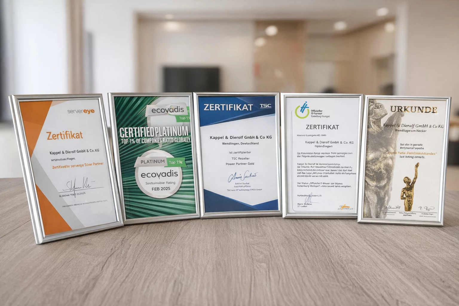 Fünf Zertifikate von Kappel & Dieroff GmbH & Co. KG in Bilderrahmen, auf einem Tisch in einem modernen Büro.